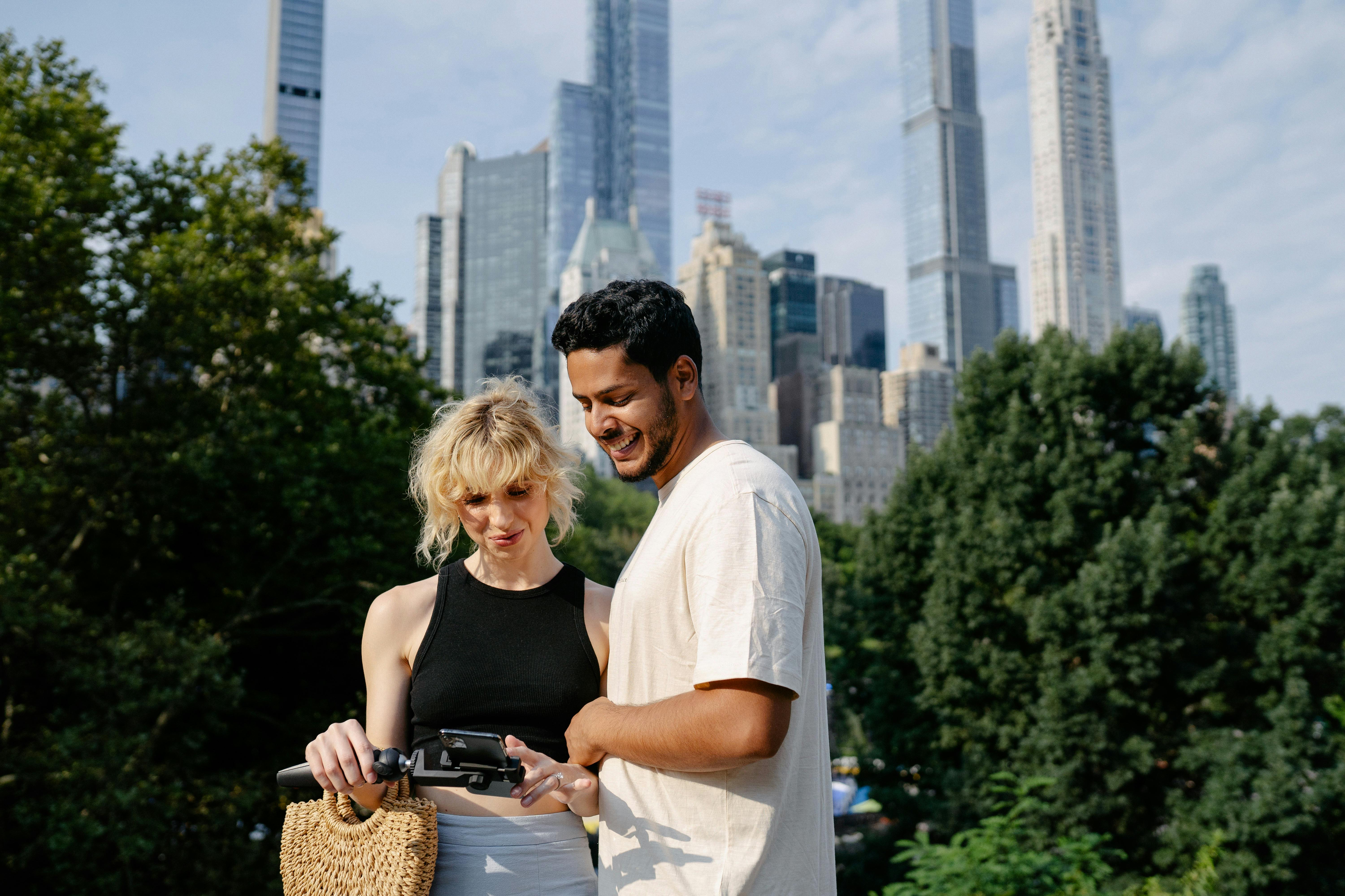 Two people on a rooftop looking at a phone